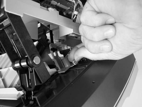8. Grasp the tab on the gear-drive arm bracket and carefully flex it away from the scanner