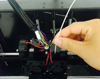 Load the filament by inserting it into the extruder at an upright angle. 4.