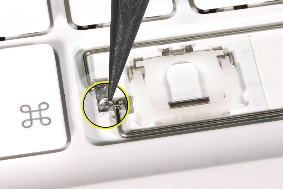 2. Because adhesive is used under the top case, closely inspect the case for any adhesive that may have built up under the keycap. Lift away any built-up adhesive using fine-point tweezers. 3.