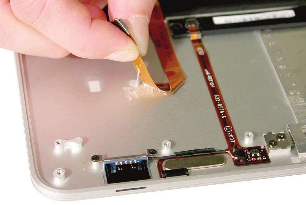 5. Slowly peel the flex cable away from the top case from each end, keeping your fingers within two inches of the