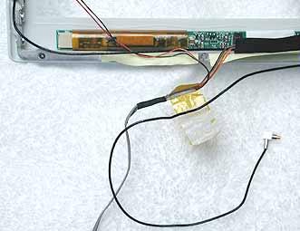 4. Warning: When removing the tape that bundles the reed switch cable assembly to the AirPort Card antenna cable, be
