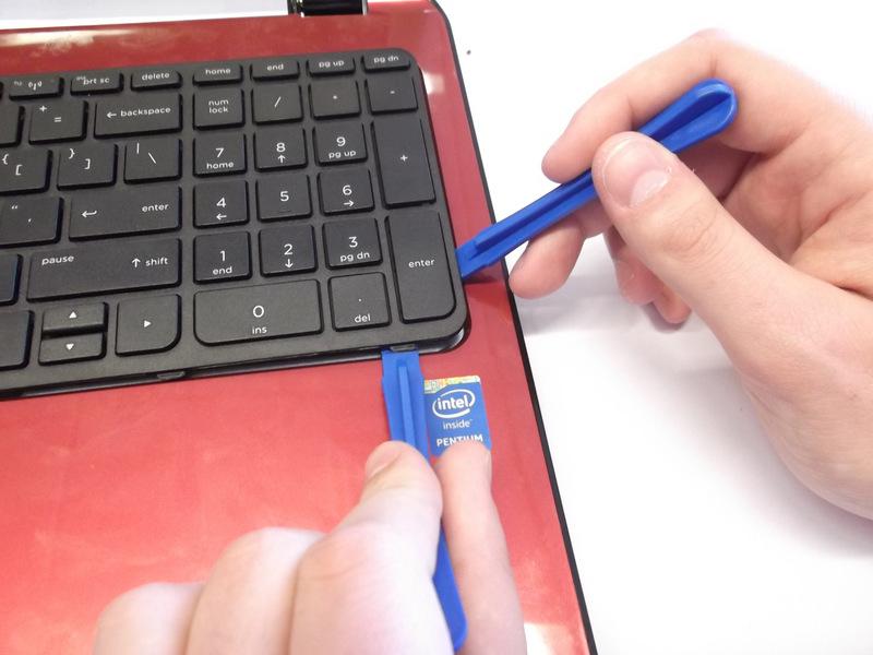 Use the plastic opening tool to pry the keyboard