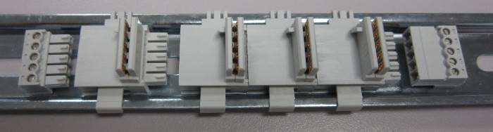 Figure 4 shows multiple TBUS connectors installed on a DIN rail. First, install the TBUS connector onto the DIN rail, then slide into adjacent TBUS connector.