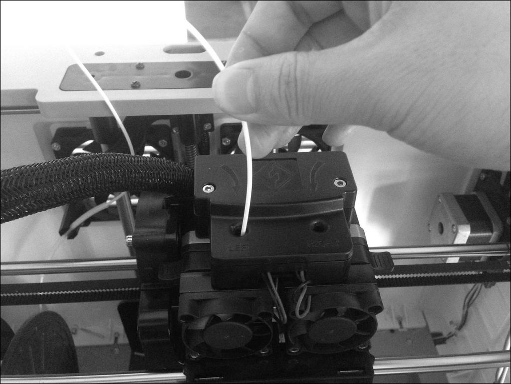 Load the filament by inserting it into the extruder at an upright angle. 5.