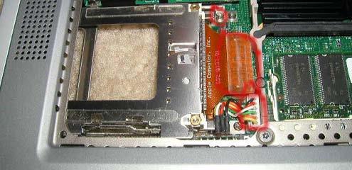 Undo the orange PCMCIA connector from the motherboard by gently prying it up.
