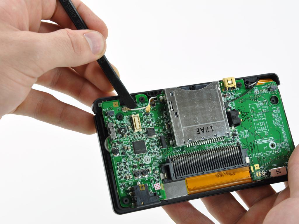 The Wi-Fi board is secured to the motherboard with a layer of adhesive. Remove the Wi-Fi board from the DS Lite.