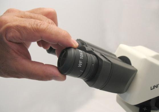 Insert the eyepiece into the right eyepiece tube by aligning the notches on the eyepiece slightly to the left of the tabs on the eyepiece tube; 