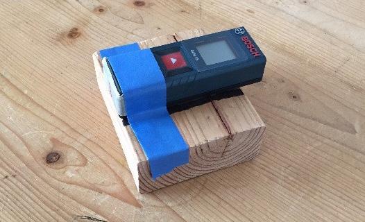 GETTING READY 1. Attach the laser measuring device to a block of wood so that its rear end is flush with the edge of the block.