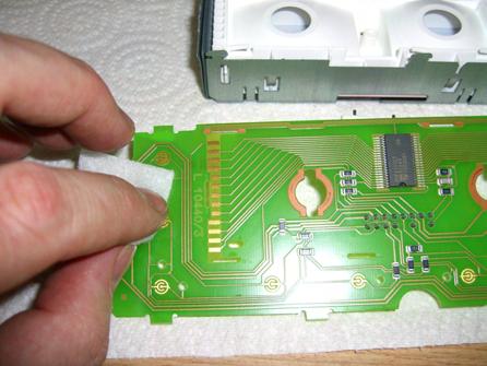 Open one of the two alcohol swab pads and use it to wipe down all metallic gold pads on the circuit board.