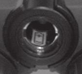 the dot on the binocular. Set the cover aside and remove the battery. Note the + and - polarity markings on the battery.