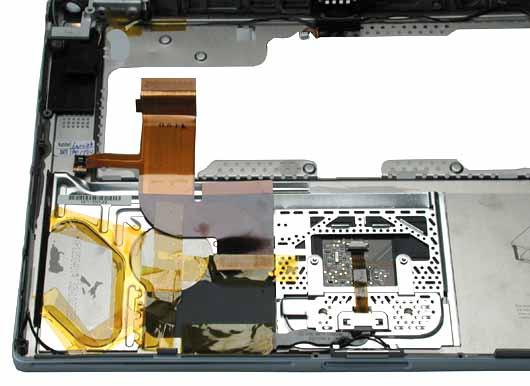 Procedure 1. With the top case on a soft cloth, notice the placement of the transparent, orange Kapton tape and the routing of the PMU ribbon cable.