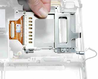 ) With the computer on a soft cloth, remove the two screws that attach the PC card cage to the rib frame.