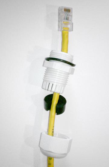 Route the RJ45 connectorized Ethernet cable through the weather tight gland connection as shown at left. Note: The slit rubber washer allows a pre-terminated Ethernet cable to be used.