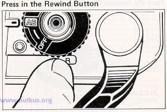 2) While pressing down the Rewind Button, wind the film with the Film Advance Lever. (The film will remain stationary, the shutter will cock, and the Exposure Counter will remain where it is.