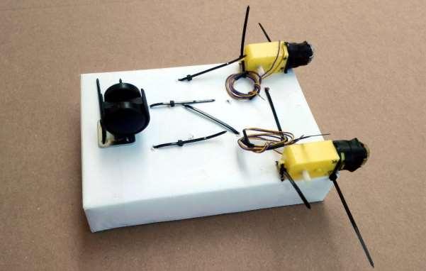 The motors are placed outside the box (not inside, where the electrical components are). 3.5.1. First attach the motors to the box using double-sided tape this will hold them in position. 3.5.2.