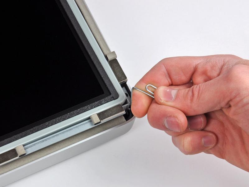Use a thin hooked tool to lift one side of the top edge of the display by its steel outer frame.