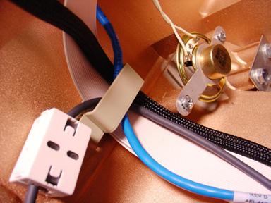 Remove the covering on a self adhesive cable clip, and place the clip to the right of the new SPED adaptor