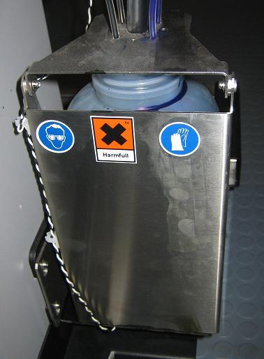 GOGGLE AND GLOVE LABEL ON THE WASTE LIQUID TANK.