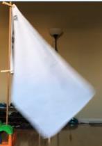 I then release the two hand held edges of the flag and observe its falling motion.