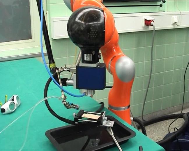 Fig. 4: Experimental system for laser ablation on bone with a KUKA lightweight robot Three experiments were performed. In a first experiment the bone was cut while the robot holds its position.