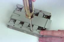 Remove the floppy disk drive carrier tray by removing the four screws and lifting it off.