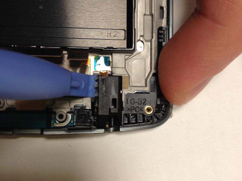 Step 9 Remove the headphone port The headphone port is kept in place with an adhesive, so