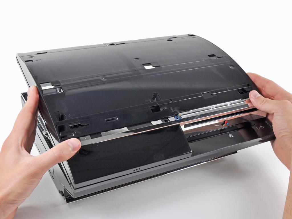 from its rear edge and rotate it toward the front of the PS3