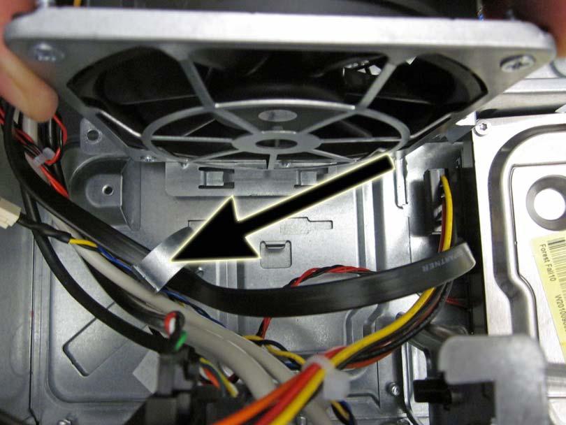 5. Remove the cables from the clip on the base pan of the computer.