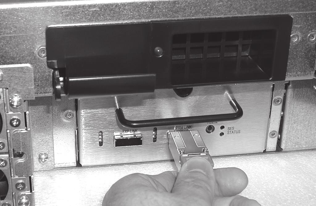 With its lever fully opened, carefully slide the drive module into any slot in the enclosure until it stops, and then secure it by pushing the lever in until it snaps closed (Figure 13).