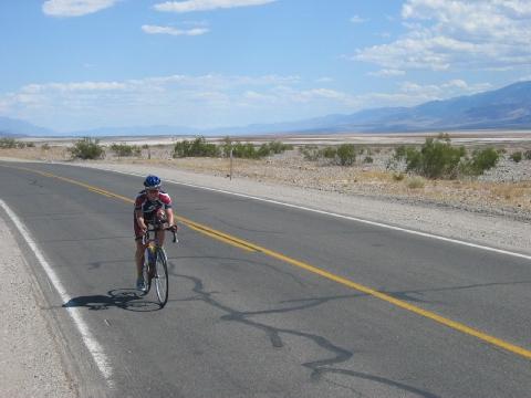 00), helmet (1.00), jersey (1.00), line (1.00), power (1.00), short (1.00), hand (1.00), road (1.00), bottle (1.00), car (1.00), sky (1.00) Ground Truth: bike (1.00), cycling (1.00), cyclist (1.