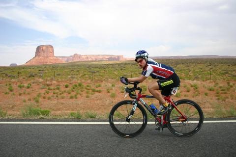 00), helmet (1.00), jersey (1.00), short (1.00), shrub (1.00), road (1.00), desert (1.00), cloud (1.00), mountain (1.00), sky (1.00) Ground Truth: bike (1.00), cycling (1.00), cyclist (1.