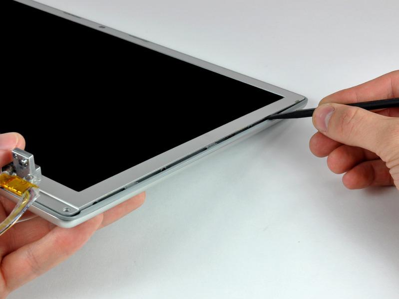 With the spudger still inserted, rotate it away from the display to separate the front and rear bezels.