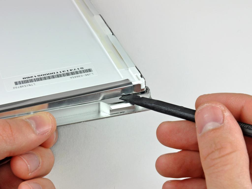 The adhesive is applied such that it sticks to a thin steel strip around the perimeter of the LCD.