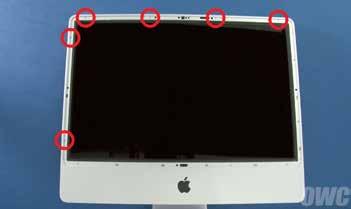 b. Carefully lay the imac on its back. 6. Next, remove the 4 middle sized screws, 2 on either side of the optical drive, and 2 in the bottom corners. 4. Begin removing the 12 Torx T8 screws that hold the front bezel in place.