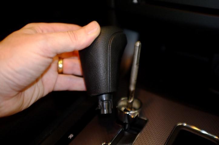 3) Remove the gear shift knob as shown 4) Release clips retaining the trim panel shown Use of