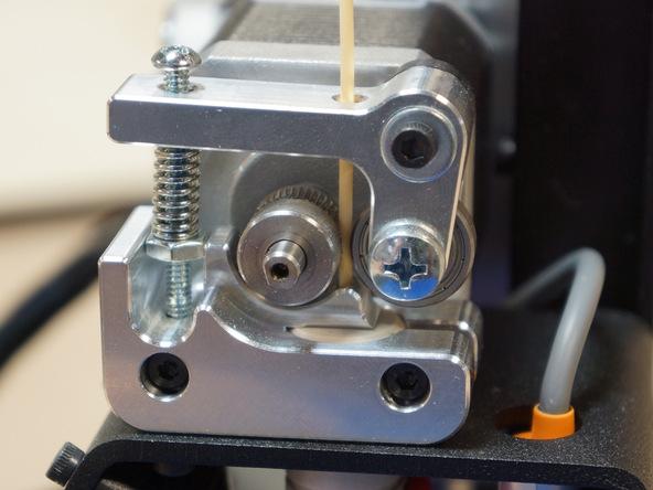 Guide the filament into the top of the extruder, past the drive gear and down the guide into the hot end.
