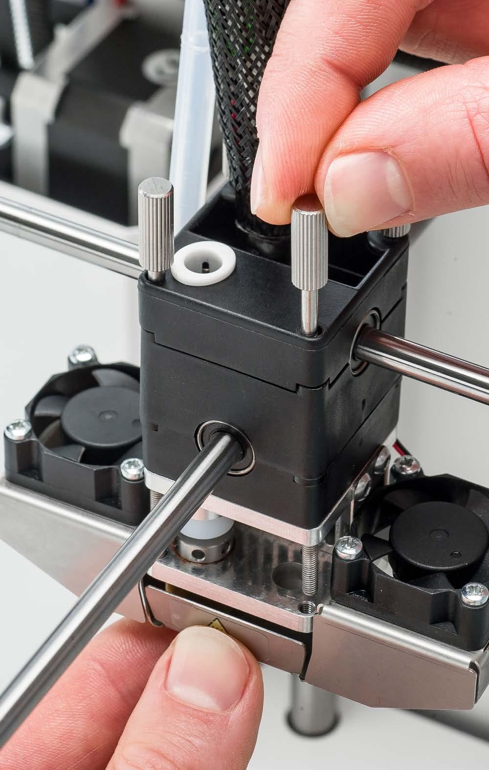 5. Attach the print head housing to the hot end Insert the four thumb screws.