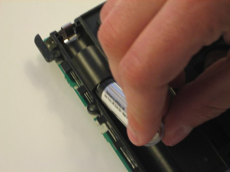 Remove the bottom batteries by pressing the battery towards