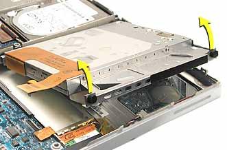 4. Warning: To prevent damage to the optical drive, handle the drive only by the corners. Do not press on the body of the drive. Gently pull up on the outer corners of the drive to remove it.