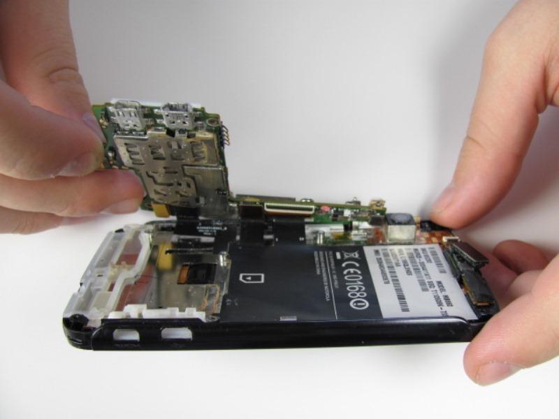 This can be done by placing a spudger in between the two ports on the phone, between the black plastic and motherboard, and