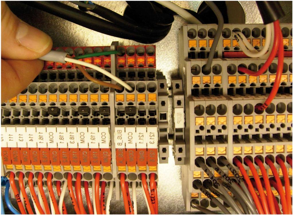. Connect the communication cable to the terminal block (control unit) as follows: Connect a wire to the X terminal block connection marked BUS_A. See position.