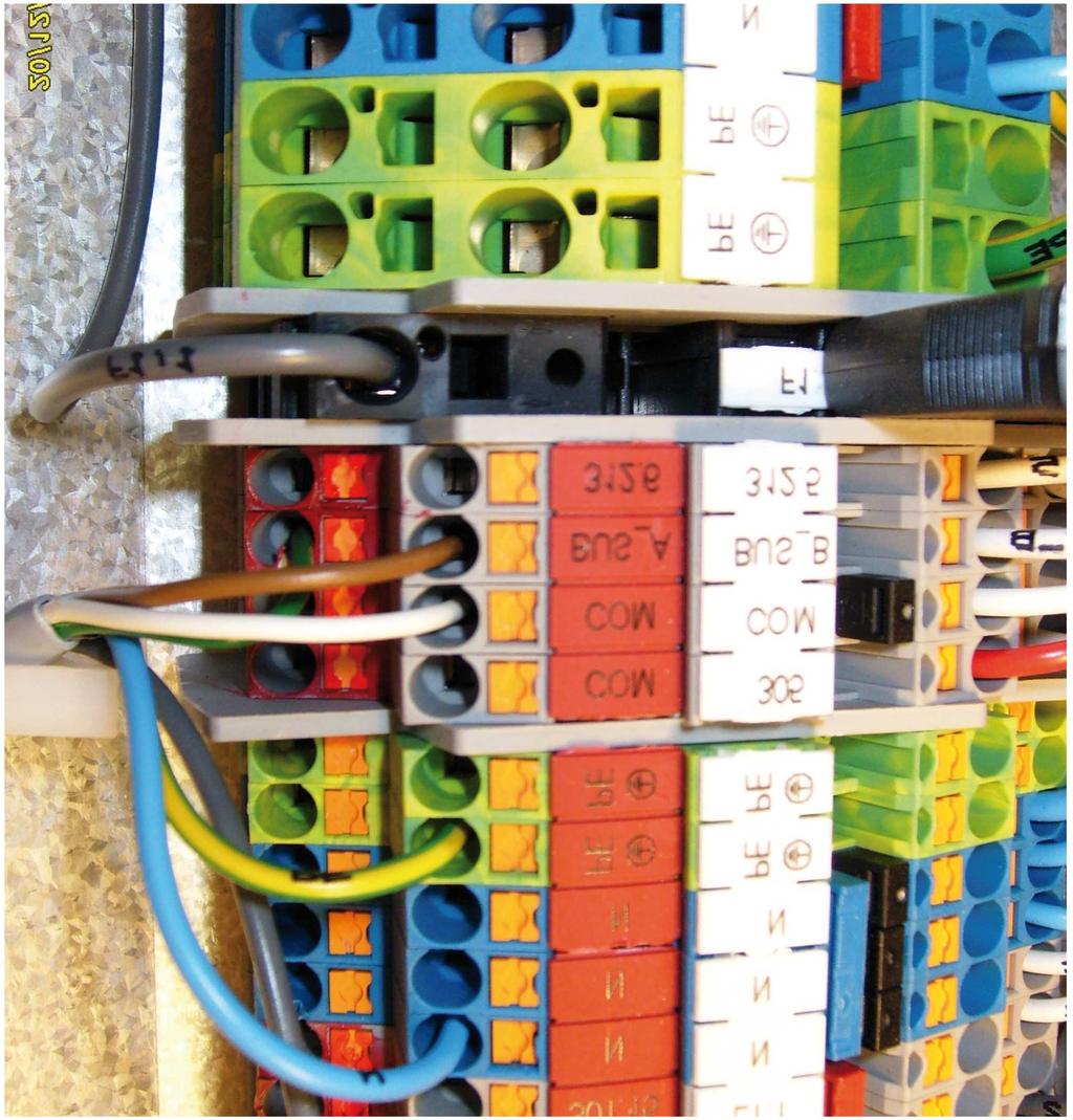 Connect a conductor to the X terminal block connection marked COM. See position.