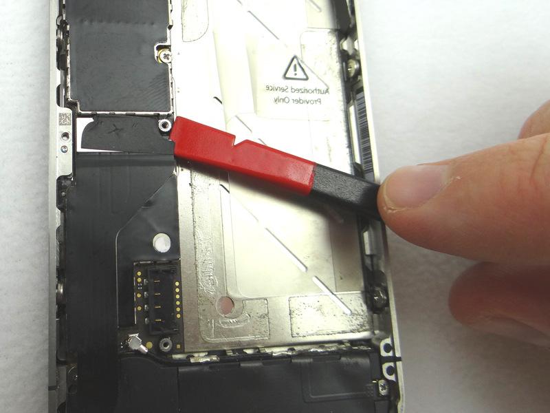 Picture 3: Place flat end of spudger under lower-right corner of the charging port assembly cable.