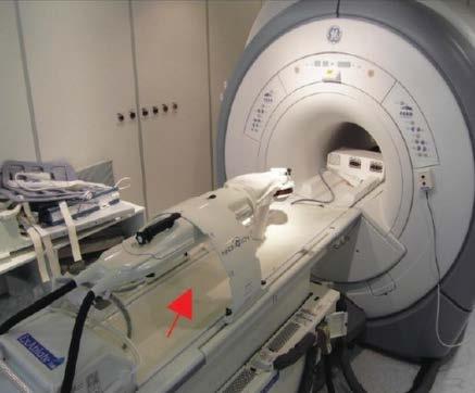 Fig. 1-3: MRI-guided surgical application of the Innomotion robotic system (red arrow). It has pneumatically actuated 5 DOF and manually actuated 2 DOF [18].