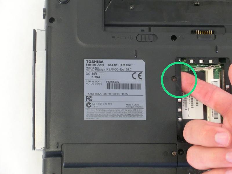 Using your index finger, push the metal tab inside the RAM bay