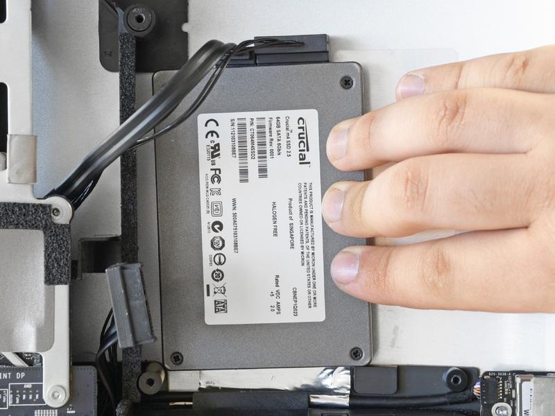 Once you are happy with the SSD's placement, firmly press down along its edges to ensure full adhesion.