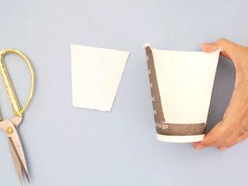 Now we'll secure the bigger trapezoid cutout to the inside of the cup with two small pieces of
