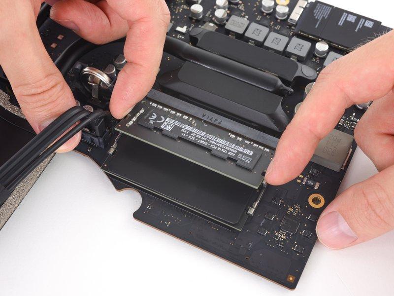 Using your fingers, spread the clips away from the RAM