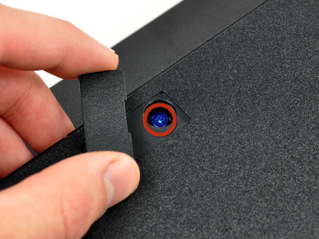 Use the flat edge of a metal spudger to pop up the small access door on the bottom cover near the front of