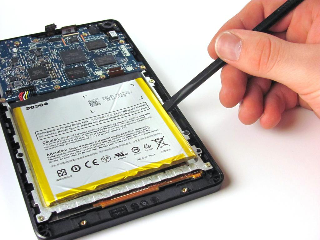 to soften the adhesive, and then slide a credit card behind the battery to break up the